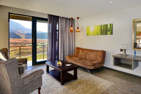 Hotel room with coffee table, chairs and mountain view